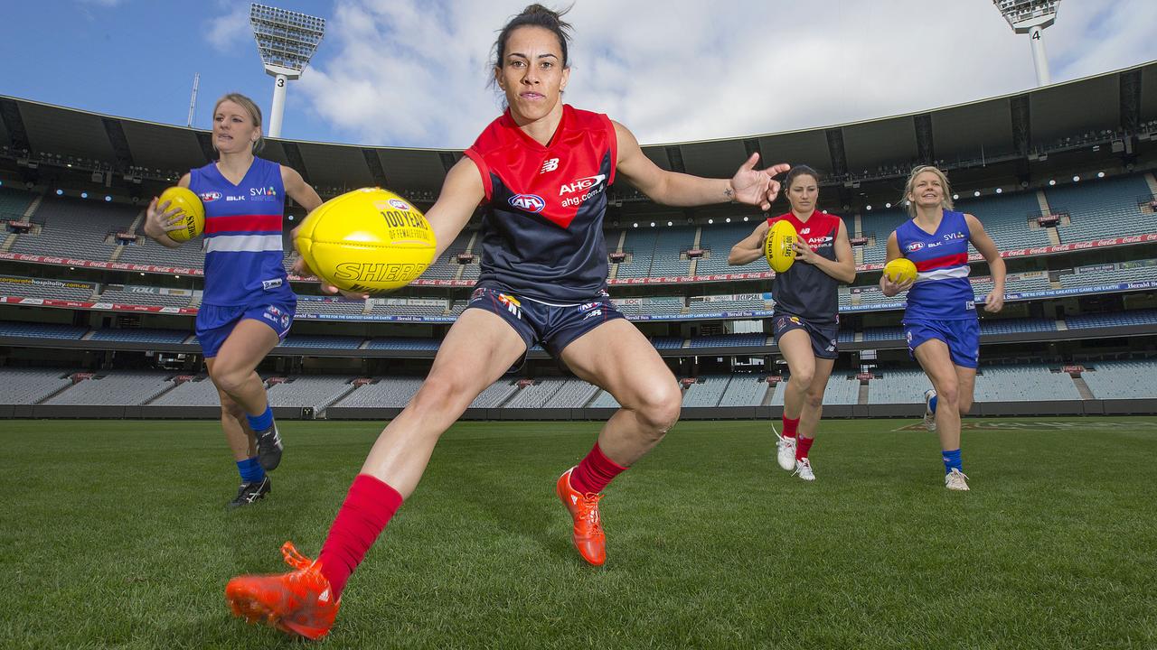 Four of the women's footballers who will be playing the curtain-raiser at the MCG this week before the Western Bulldogs v Melbourne game. Kirby Bentleigh (Swan Districts) leads from the front with her Melbourne footy jumper and ball.Picture:Ian Currie