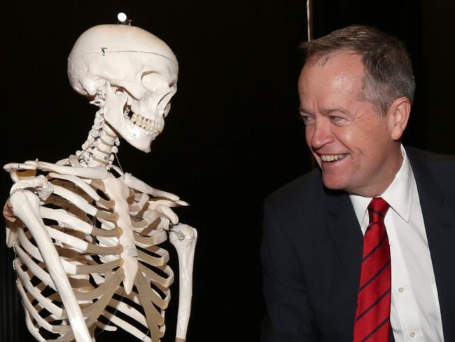 Bill Shorten shakes hands with a skeleton, calling it Tony Abbott, at Victoria University in Footscray.