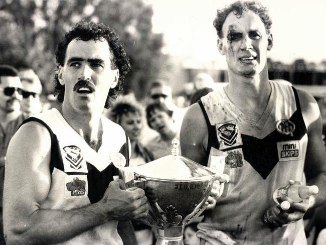 File Photo : Southport captain Zane Taylor (L) and bloodied Gary Dempsey with the Mini Skips-QAFL Cup after the Sharks 23 point win over Windsor-Zillmere