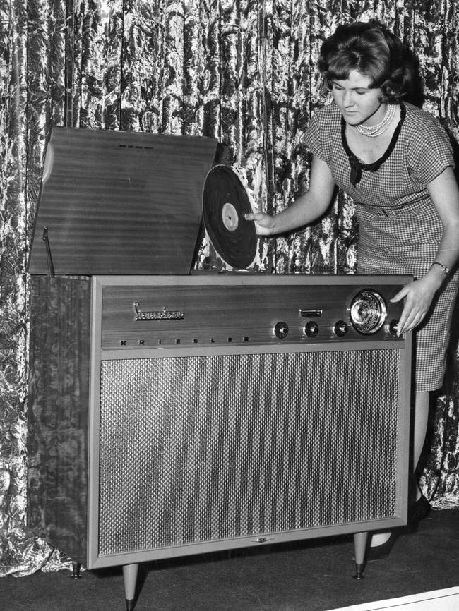 A woman placing vinyl record into a radiogram in 1961.