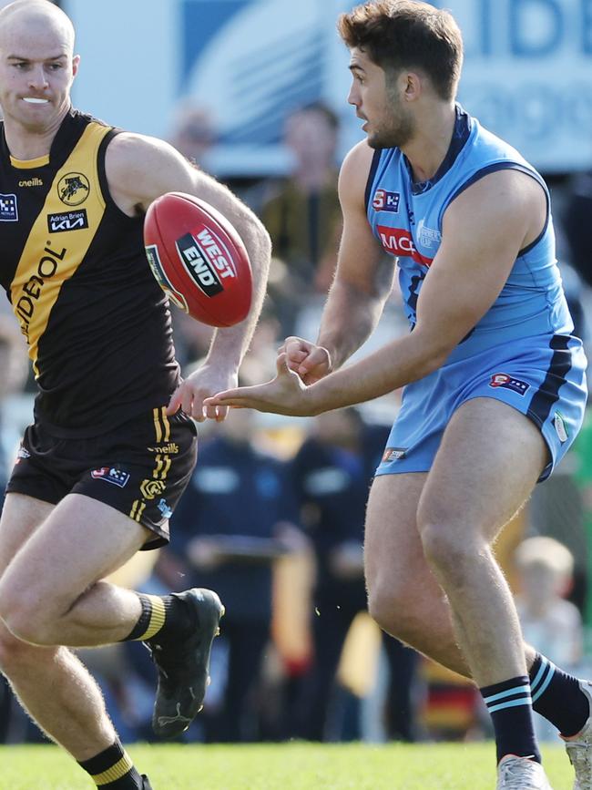 Sturt’s James Battersby dishes out a handball under pressure from Glenelg’s Cole Gerloff. Picture: David Mariuz/SANFL