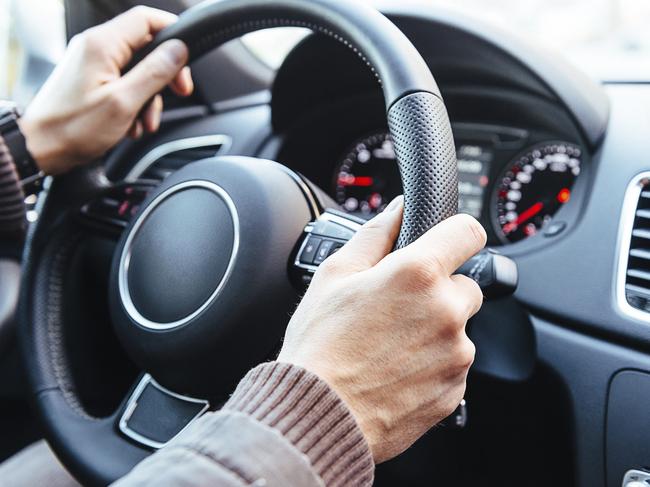 Male hands on the steering wheel of a car. Picture: Istock