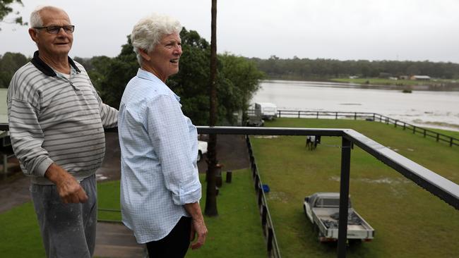 Reg and Lorraine Smith looking on as the Hawkesbury River rises in McGraths Hill, Sydney. The Smiths are determined to ride out this flood, but they concede evacuating could be their only option. Picture: Jane Dempster