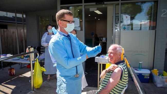 Westgate Health Co-Op in Newport observes social distancing while administering influenza vaccinations. Dr Stephen O'Shea gives Frank Vanderlinden, 78, his shot. Picture: Mark Stewart