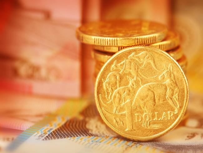 Australian Dollar Coin.  Note this is a circulated coin so has some nicks and scratches.  Stock image of a pile of Australian dollars with Australian money in background generic