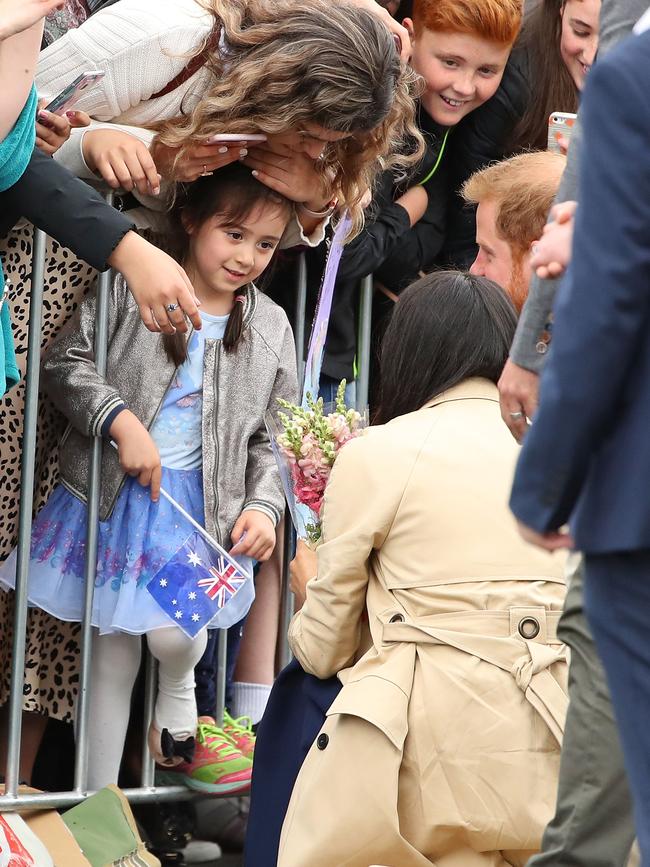 Meghan receives some flowers form a young fan. Picture: Getty