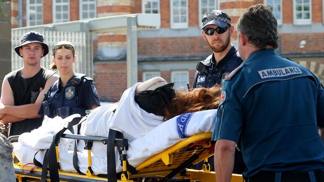 A woman is taken away by ambulance after collapsing outside of the Stereosonic festival in Brisbane yesterday.