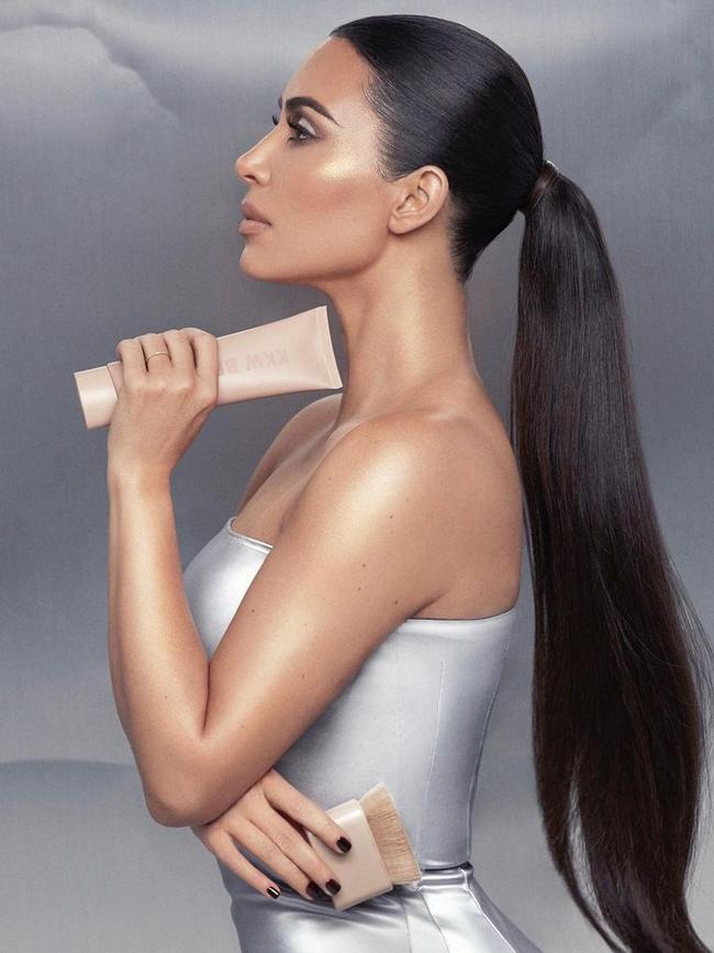 Kim Kardashian clutching the KKW Beauty Skin Perfecting body shimmer.