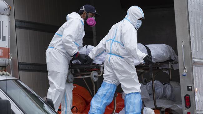 Workers move bodies to a refrigerated truck in Brooklyn. Picture: AP