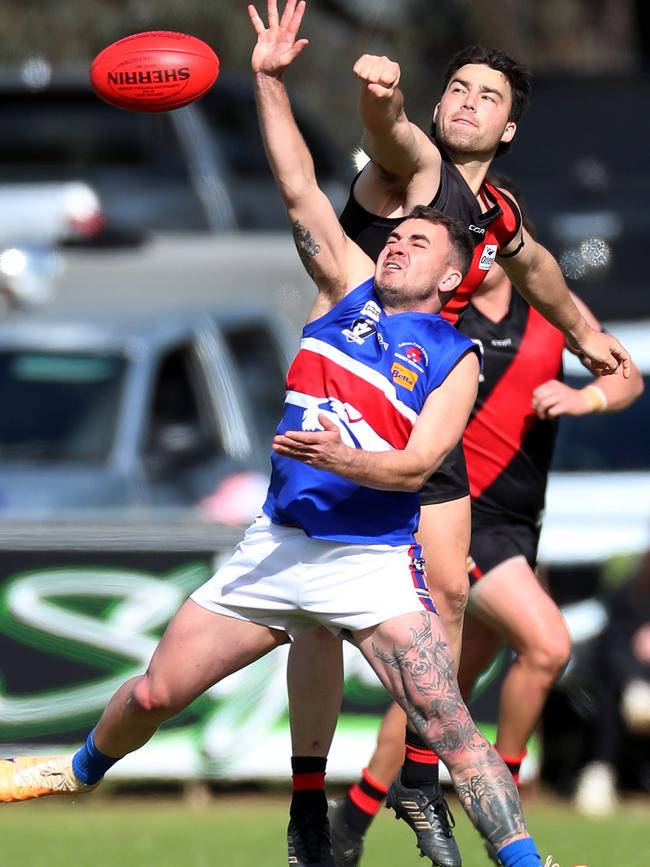 Waaia’s William Foster punches the ball clear of Strathmerton’s Darcy McCormack.