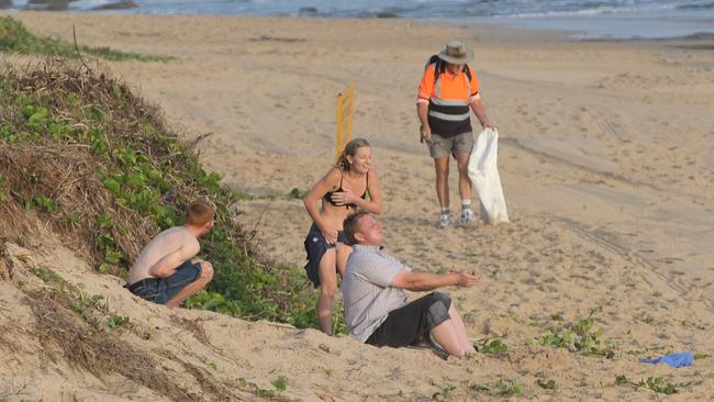 A council contractor cleans up the mess from the night before as revellers soak up the first rays of light on Mooloolaba Beach after an early morning dip in 2010. Picture: Brett Wortman.