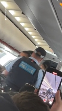 Allegedly drunk Jetstar passenger is escorted off a plane by five cops