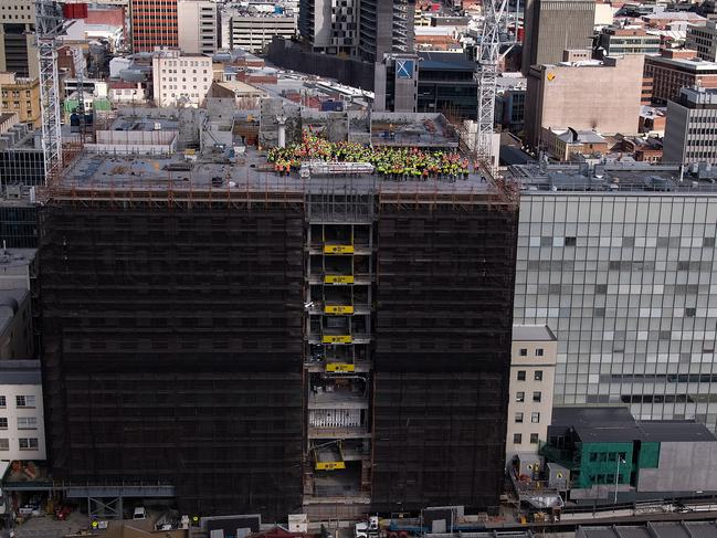 Workers celebrate with a barbecue and “topping out” ceremony on the Royal Hobart Hospital K Block’s roof after the main concrete structure was completed this week.