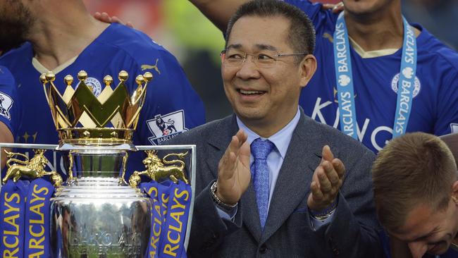 Vichai Srivaddhanaprabha applauds beside the trophy as Leicester City celebrate becoming the English Premier League soccer champions at King Power stadium. Picture: AP