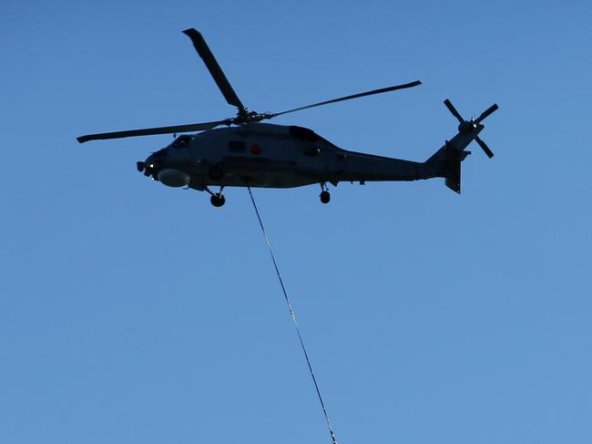 Pictured is a flypast by a Australian Navy Seahawk Helicopter flying a large International Fleet Review flag, accompanied by a Squirrel helicopter in International Fleet Review livery over Sydney Harbour today.