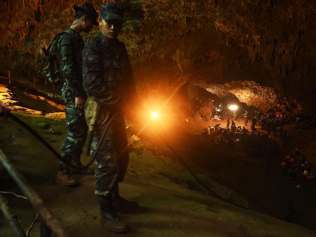 Thai soldiers relay electric cable deep into the Tham Luang cave.