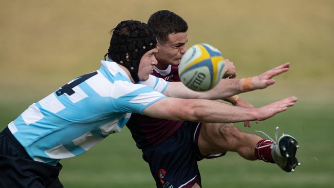 Queenslander Finn Lawson gets a kick away despite the close attention from a NSW rival at the Australian schools rugby championships. Picture: Julian Andrews