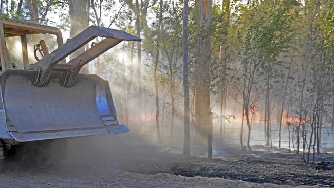 ABOVE: A bulldozer reinforces containment lines of an out of control bushfire at Whiteman Creek on Saturday. INSET, TOP RIGHT: Copmanhurst RFS captain Edwin Newbery was awarded the NSW RFS Officer of the Year at the Rotary NSW Emergency Services Community Awards. INSET, RIGHT: Edwin Newbery was back at work yesterday collecting waste for JR Richards &amp; Sons. Picture: Bill North