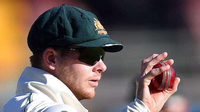 (FILES) In this file photo taken on November 23, 2019, Australia's Steve Smith holds the ball on day three of the first Test cricket match between Pakistan and Australia at the Gabba in Brisbane. - A two-year leadership ban slapped on Steve Smith after the ball-tampering scandal in South Africa ended on March 29, 2020, leaving the master batsman free to skipper Australia again. (Photo by Saeed KHAN / AFP) / -- IMAGE RESTRICTED TO EDITORIAL USE - STRICTLY NO COMMERCIAL USE --