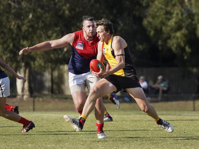 Cheltenham’s Myke Cook with the ball in front of Bentleigh’s Chris Evans. Picture: Valeriu Campan