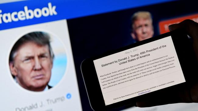 A phone screen displays the statement of former US President Donald Trump on his Facebook page background. Picture: AFP