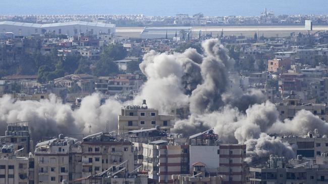 Smoke rises between buildings hit in an Israeli airstrike in Dahiyehnear Beirut’s airport. Picture: AFP.