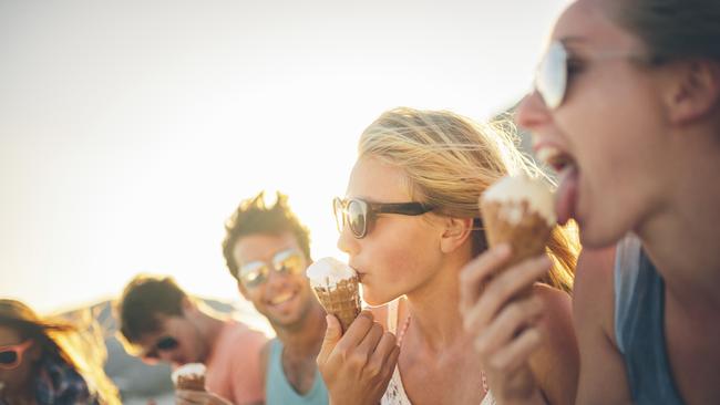 Friends eating icecream on beach