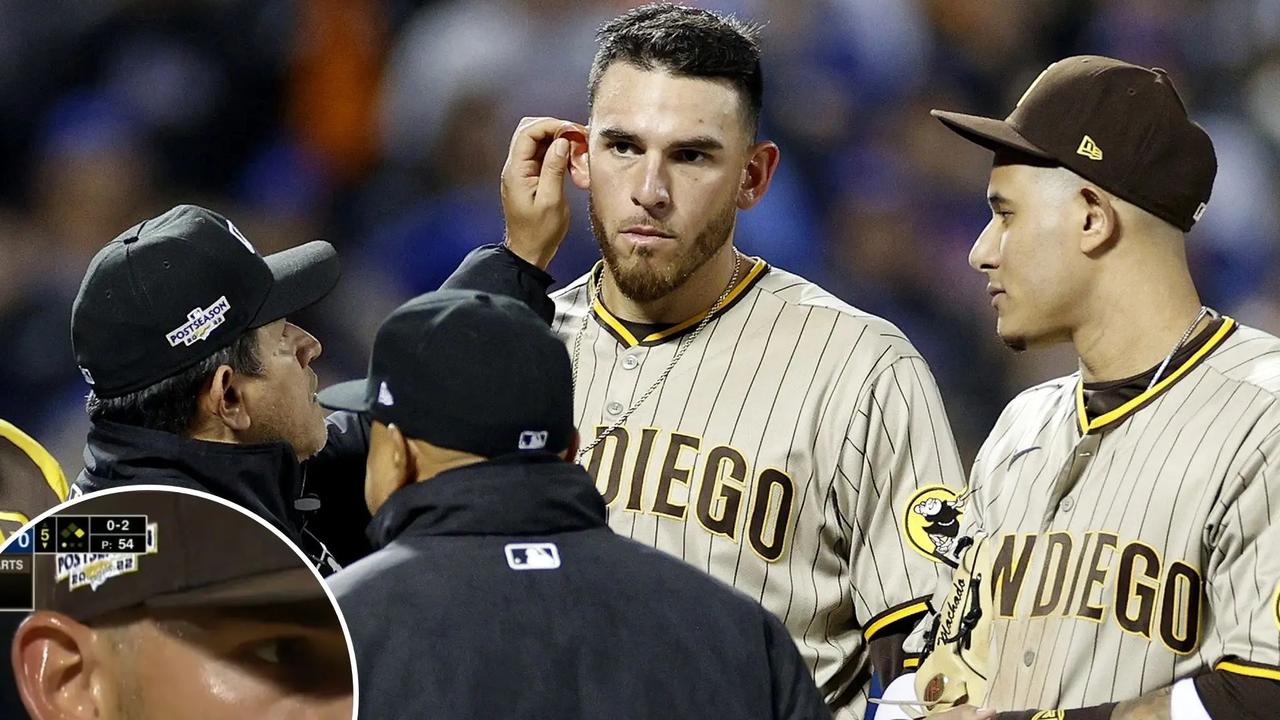 The umpire checks Padres pitcher Joe Musgrove's ear for a foreign substance.