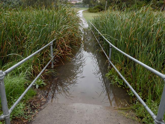 The flooded walkway is causing havoc for two men who use mobility scooters. Picture: Kylie Else