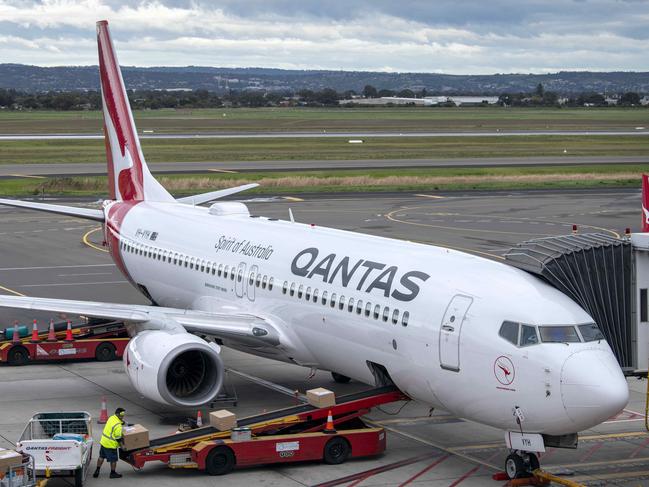 ADELAIDE, AUSTRALIA - NewsWire Photos August 10, 2022: Baggage handlers load luggage on a Qantas aircraft at Adelaide Airport.Qantas will increase the waiting time between domestic to international connecting flights by 30 minutes in an effort to mitigate the number of people arriving at their destination without their luggage and has asked executives to work as baggage handlers for three months. Picture: NCA NewsWire