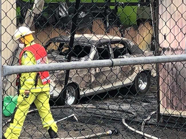 A firefighter outside the remains of a storage shed containing a number of rare and collectable cars. Picture: Jim O'Rourke