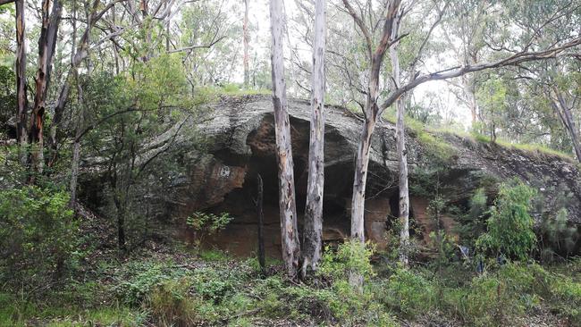 One of the cave sites which has been destroyed by thieving and graffiti. Wonnarua elder Uncle Warren Taggart at one of at least five Hunter Valley caves where thieves have chiselled out indigenous art dating back thousands of years. Picture by Peter Lorimer.