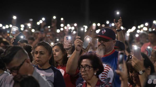 People hold up phones during a prayer and candle vigil after a shooting left 20 people dead at the Cielo Vista Mall Wal-Mart in El Paso, Texas. Picture: AFP