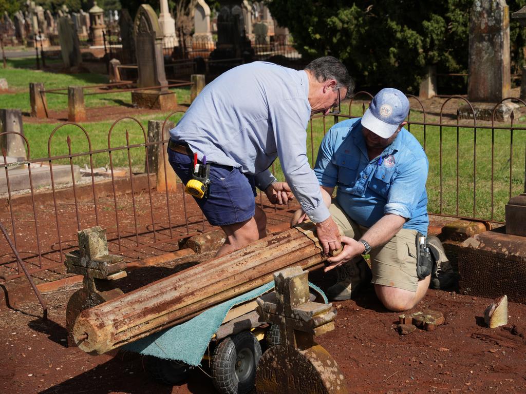 Michael Wagner and Ben Dawson working to restore the gravestones in Drayton Cemetery that were vandalised last year, as part of the Headstone Healing Project.