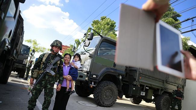 A mother and daughter with a soldier guarding the area near a pro-government demonstration site. Picture: AP