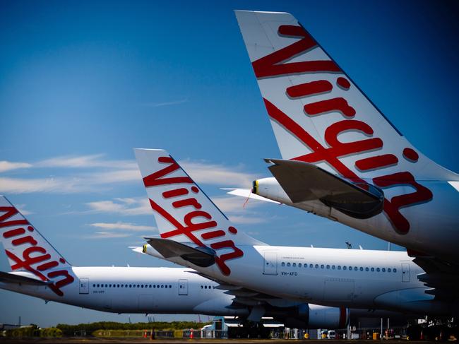 Virgin Australia aircraft are seen parked on the tarmac at Brisbane International airport on April 21, 2020. - Cash-strapped Virgin Australia collapsed on April 21, making it the largest carrier yet to buckle under the strain of the coronavirus pandemic, which has ravaged the global airline industry. (Photo by Patrick HAMILTON / AFP)