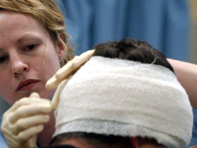 24/01/2004. Friday night at the Western Hospital, Footscray Emergency Dept. Nurse Anjella Buckley bandages up the head of a man who was assulted. DIGITAL