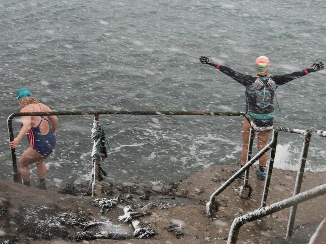 Members of the Battery Belles and Buoys, a wild sea swimming group that swim every day in the sea at from the Battery Rocks in Penzance take a dip in the sea as heavy snow arrives on February 28, 2018 in Cornwall, England. Freezing weather conditions dubbed the “Beast from the East” has brought snow and sub-zero temperatures to many parts of the UK. Picture: Getty Images