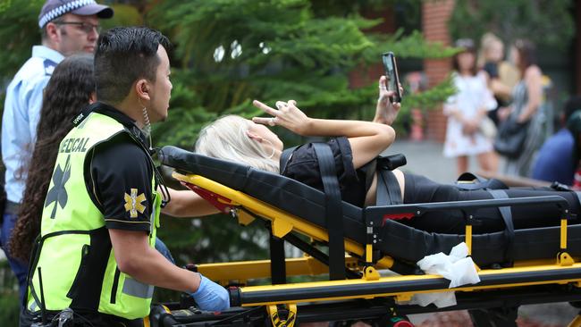 A girl takes a selfie as she is taken away on a stretcher outside the Rolling Loud Festival, Sydney Olympic Park in January 2019. Picture: Damian Shaw