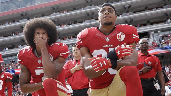 Former San Francisco quarterback Colin Kaepernick (L) and safety Eric Reid kneel during the national anthem.