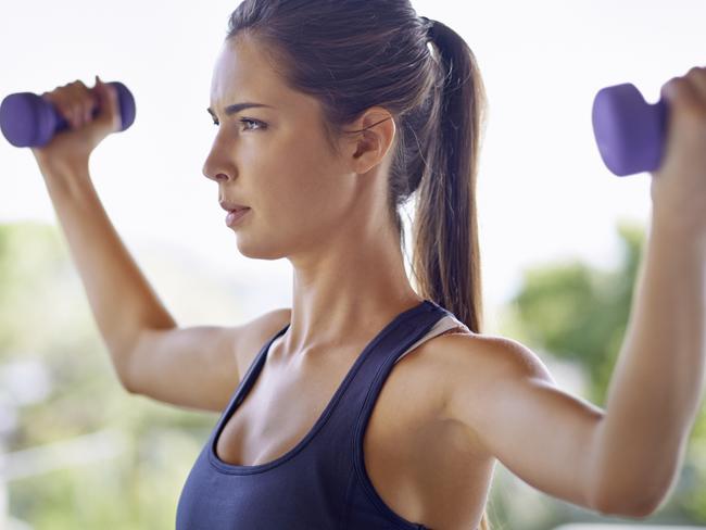 Shot of an attractive young woman working out with weights