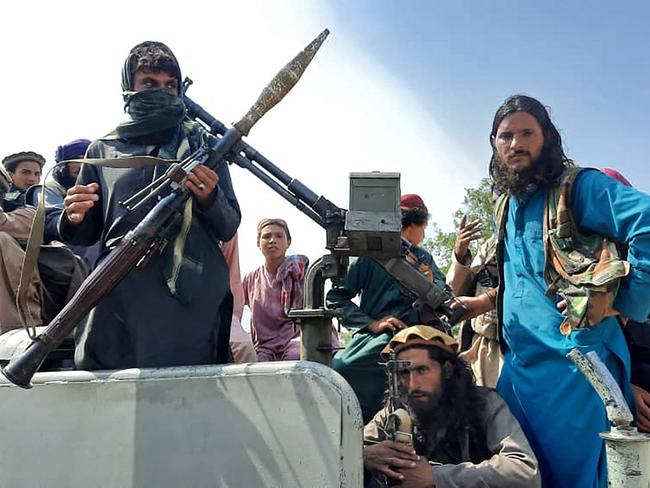 Taliban fighters sit over a vehicle on a street in Laghman province on August 15. Picture: AFP