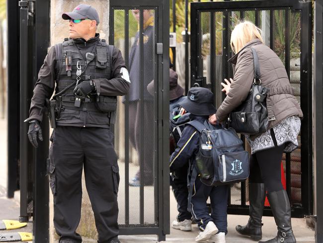 Jewish school children in Sydney's eastern suburbs enter the gates under armed guard amid a rise in anti-Semitism post-October 7.