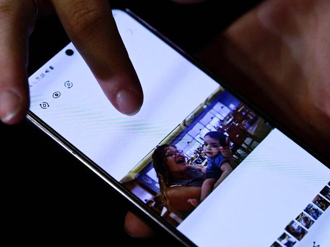 Zemer Weiss, daughter in-law of late Israeli hostage Yehudit Weiss, shows a picture on her telephone of her late mother in-law holding her toddler. Picture: AFP