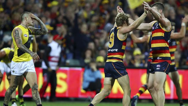 Adelaide Crows’ Rory Sloane and Josh Jenkins celebrate as Richmond’s Dustin Martin looks on.