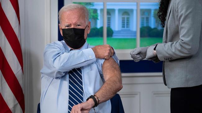 Joe Biden rolls his sleeve to receive a booster shot of the Pfizer vaccine in the White House on Tuesday (AEST). Picture: AFP