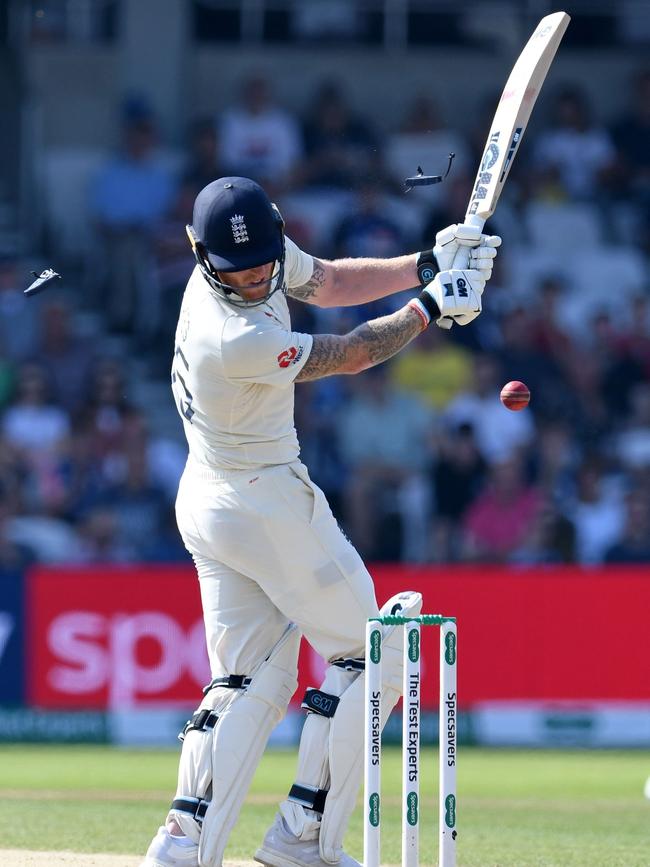 Both stemguards are knocked from Ben Stokes’ helmet as he’s hit in the heat by a Josh Hazlewood bouncer. Picture: AFP