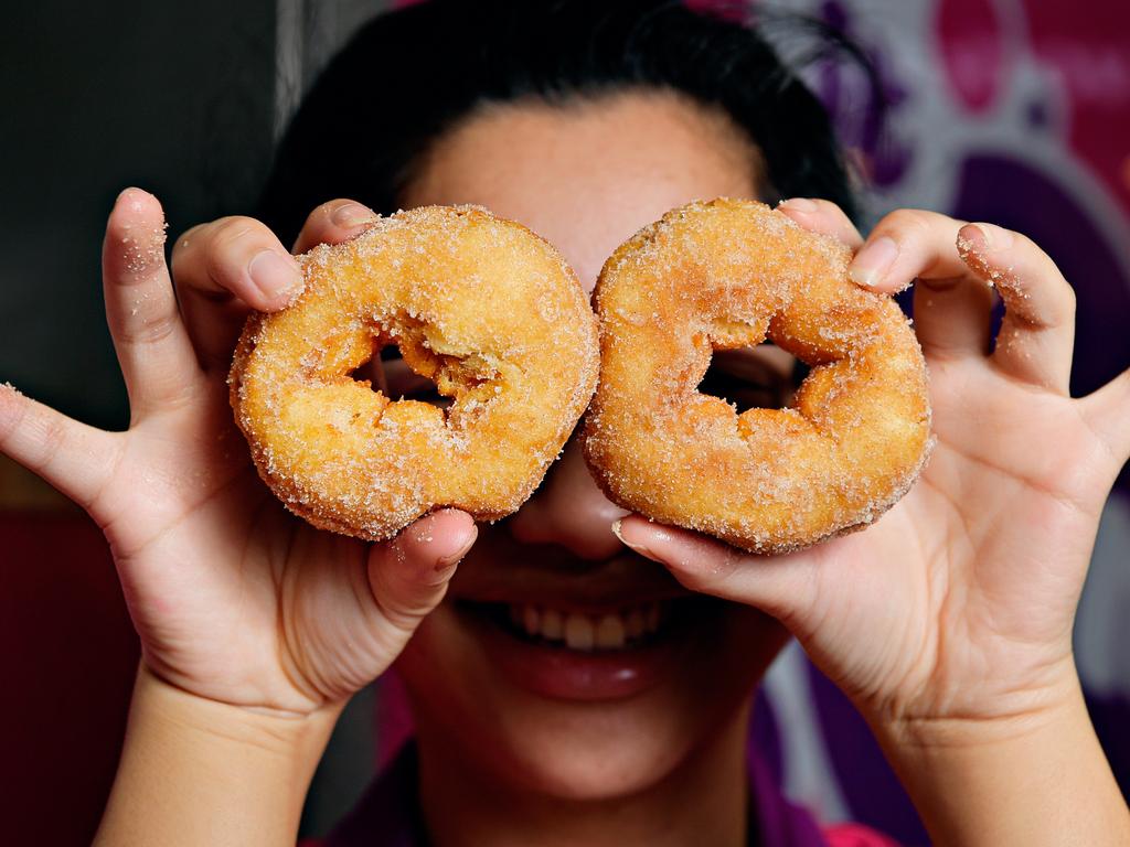 Fiona Sang prepares one of the last batches of cinnamon doughnuts on sale at Donut King as the store prepares to close its doors at Casuarina Square.
