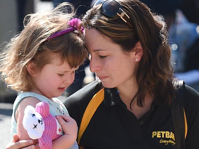 A mother and her young daughter react as they pay their respects to four people who died yesterday at amusement theme park Dreamworld on the Gold Coast, Queensland, Wednesday, Oct. 26, 2016. Four adults, two men and two women, died yesterday when the park's Thunder River Rapids ride malfunctioned. (AAP Image/Dan Peled) NO ARCHIVING