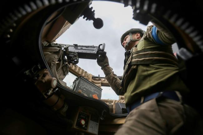 A Ukrainian serviceman mans a machine gun in an MRAP armored vehicle on June 16, 2023